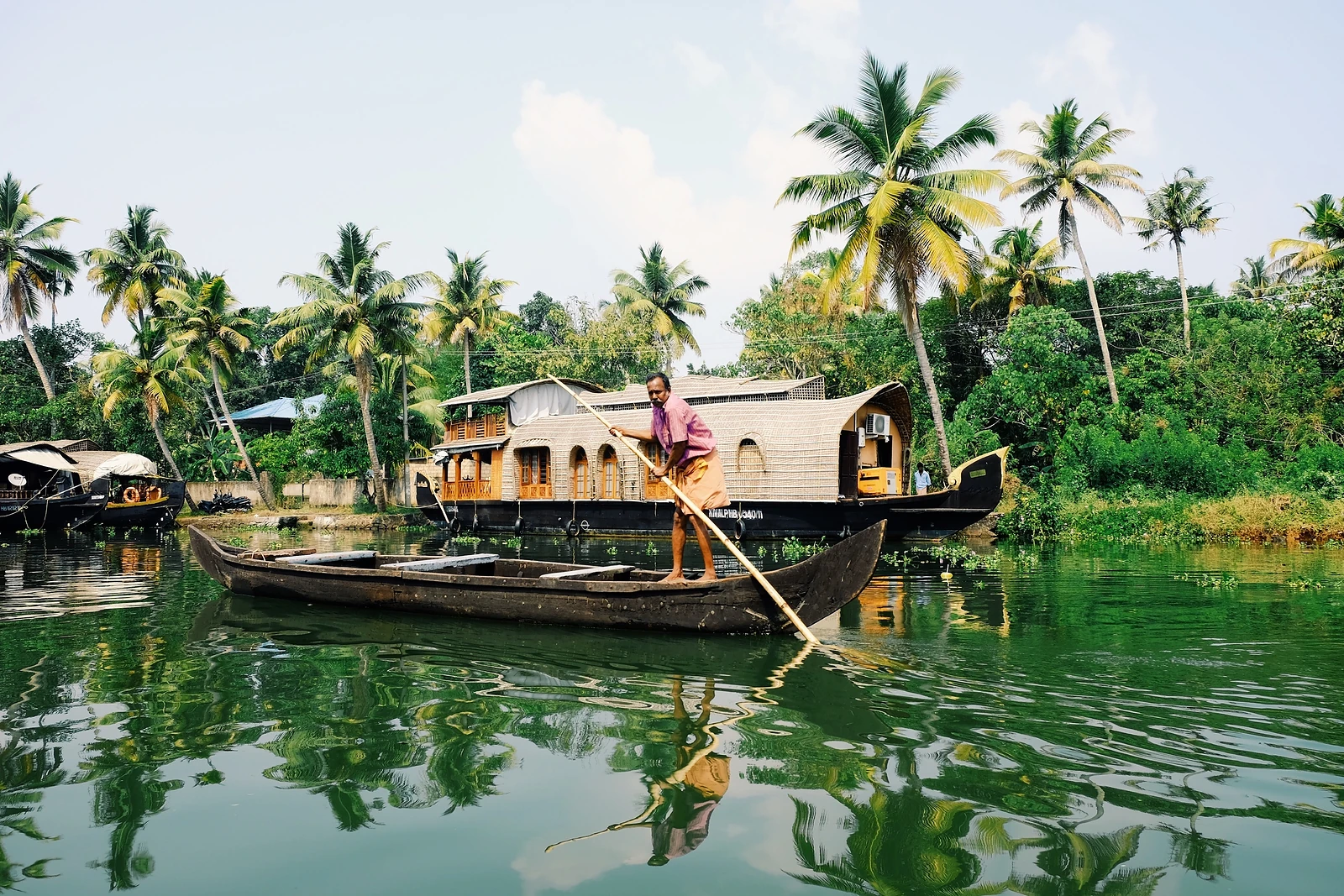 Kerala houseboat on a backwater lined with palm trees